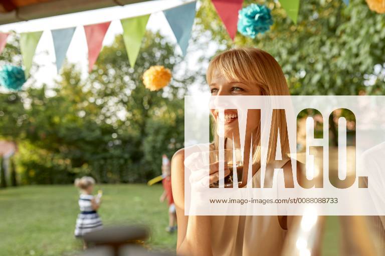 Happy woman drinking coffee on a garden party model released Symbolfoto property released ZEDF01649