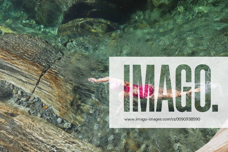 Switzerland, Ticino, Verzasca Valley, woman swimming in refreshing Verszasca river model released Symbolfoto GWF05955