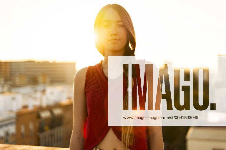 IMAGO Creative, Jahreszeit Sommer, Sommerferien Portrait of teenage girl on roof terrace in the city at sunset model released Symbolfoto ERRF00947