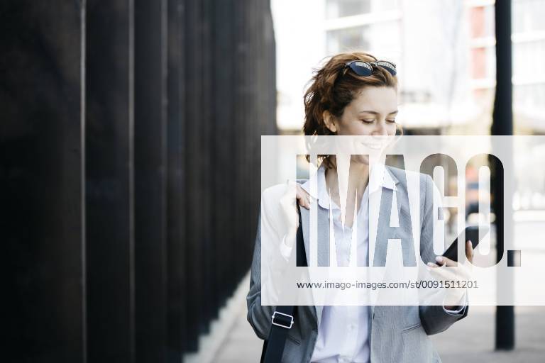 Businesswoman with smartphone, commuting in the city model released Symbolfoto JRFF03058