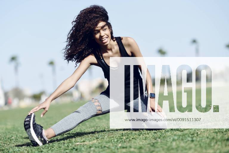 Sporty young woman stretching outdoors model released Symbolfoto JSMF00840