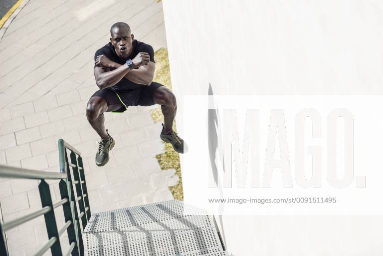 Man in black sportswear jumping in the air on staircase model released Symbolfoto JSMF00942