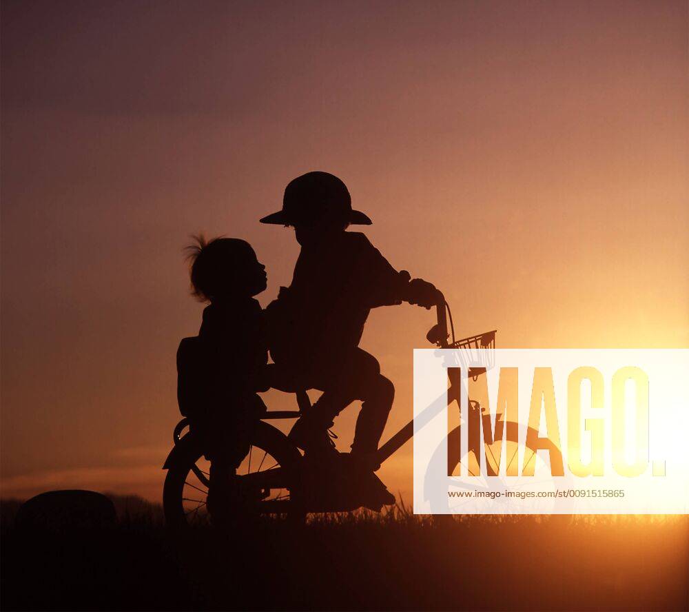 Silhouette of two children riding bicycle in sunset model released Symbolfoto WWF04913