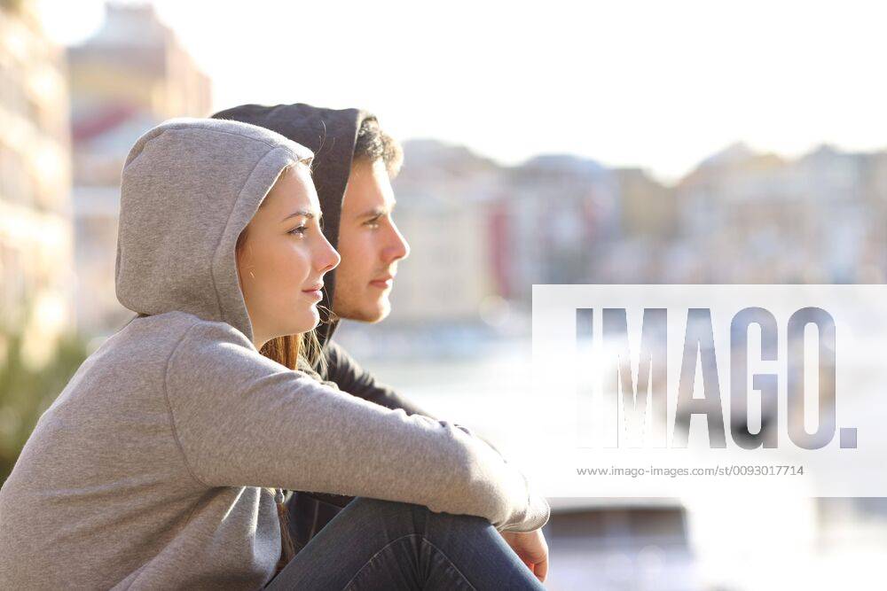 IMAGO Creative, Jahreszeit Sommer, Sommerferien Couple of teens contemplating horizon in a coast town ,model released, Symbolfoto