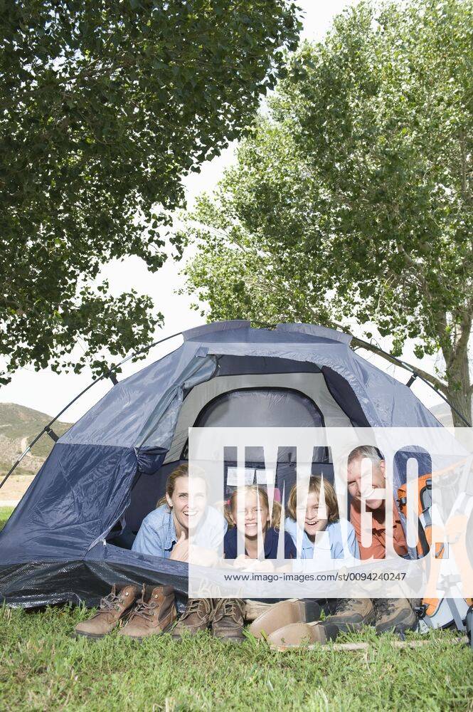 Family of four smiling from a tent,model released, Symbolfoto,property released 03B86872