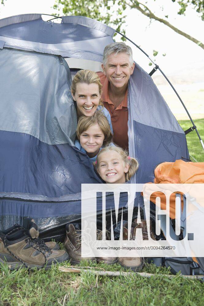 Family of four smiling from a tent,model released, Symbolfoto,property released 03C05341