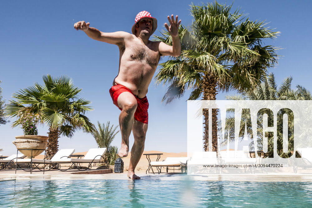 Overweight man jumping into swimming pool model released Symbolfoto OCMF00792
