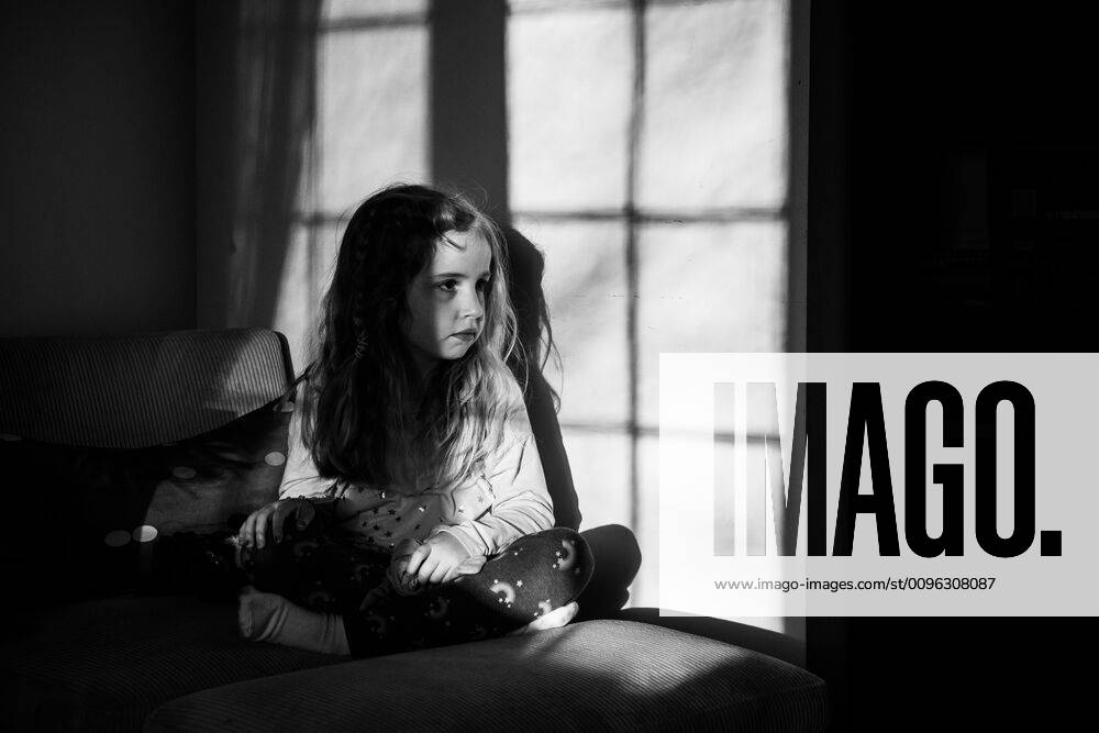 IMAGO Creative: Gesellschaft, Armut A little girl sits in the shadow of a window. Garden City South, New York, USA CR_FRRU191112-229756-01