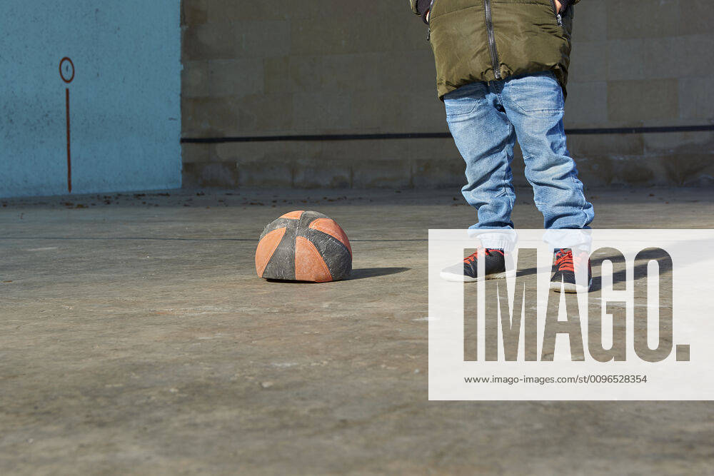 IMAGO Creative: Gesellschaft, Armut Boy with his hands in his pockets next to a deflated basketball ball. Oiz, Navarra, Espana CR_KAJO191205-248935-01