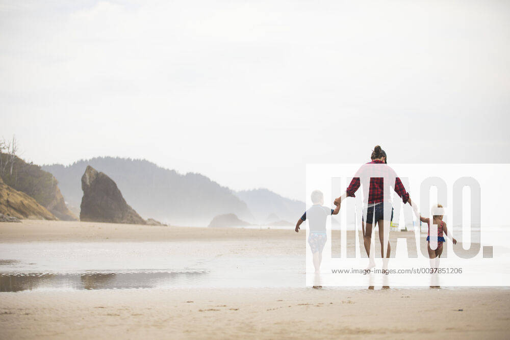 Rear view of mother walking on beach with her two young children. Manzanita, OR, United States ,model released, Symbolfoto CR_JDIP200116A-282580-01