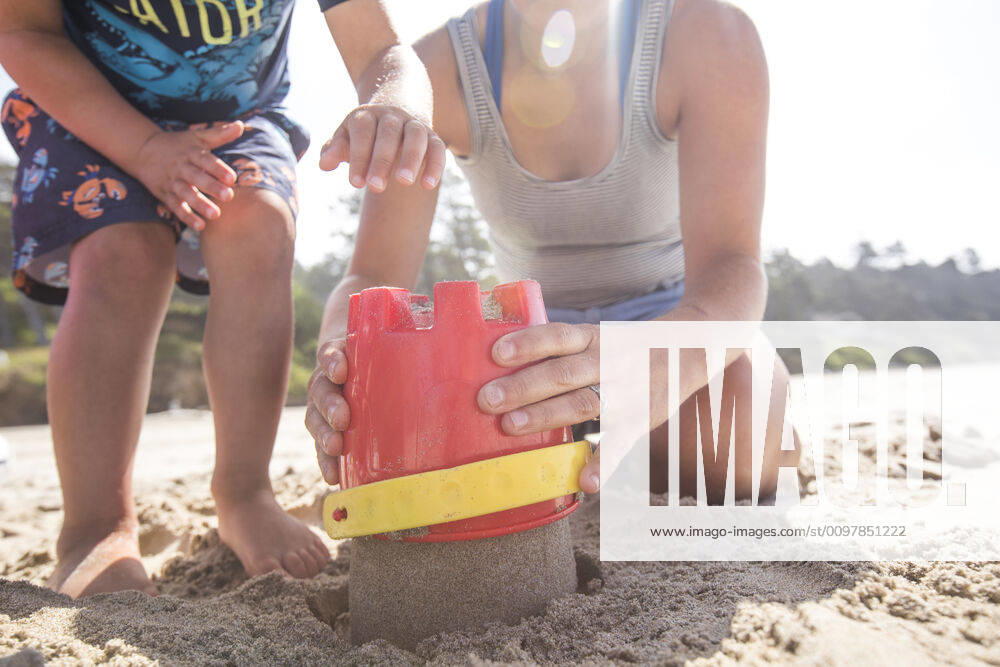 Low angle of mother and son building sand castle. Manzanita, OR, United States ,model released, Symbolfoto CR_JDIP200116A-282606-01