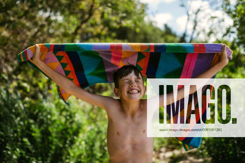 Young boy with towel at beach on summer vacation with a big smile Canada, Ontario, Kincardine ,model released, Symbolfoto CR_KEMA200116D-290614-01