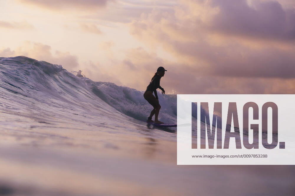 Young woman surfing at sunset Lombok, Nusa Tenggara Bar., Indonesia ,model released, Symbolfoto CR_KOTRIN200120S-290421-01