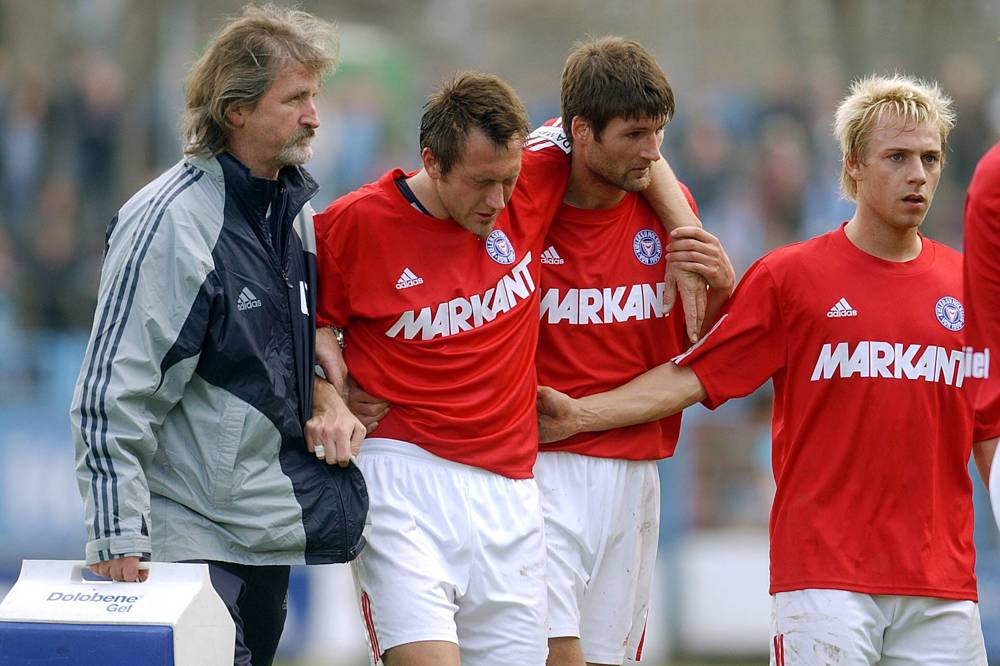 Jan Sandmann Der verletzte Sven Boy (2.v.re.) wird von Masseur Uwe Tischer (li ...