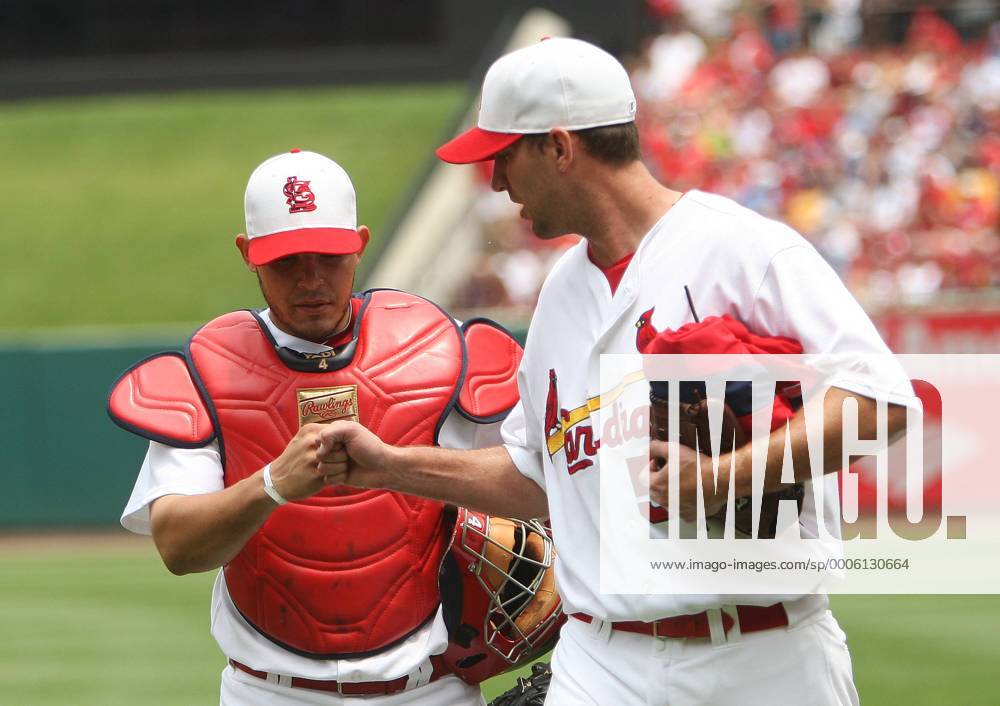 St. Louis Cardinals starting pitcher Adam Wainwright (R) bumps fists with  catcher Yadier Molina as they walk in from the bullpen before a game  against the Washington Nationals at Busch Stadium in