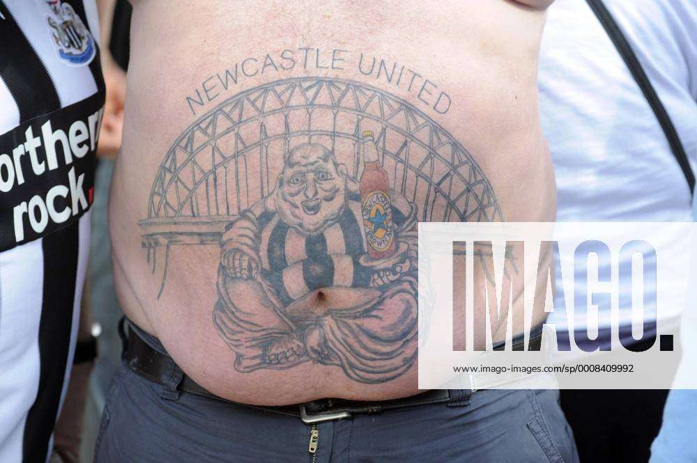 A Newcastle fan unveils a tattoo on his belly ahead of the Premier League  football match