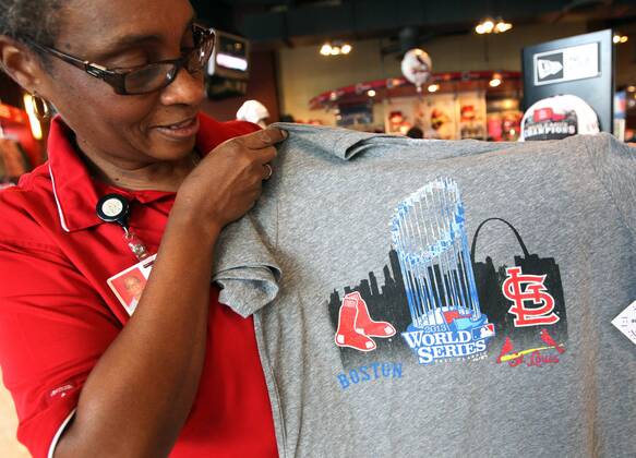 Busch Stadium Team Store manager Marceline Brooks, puts up a new