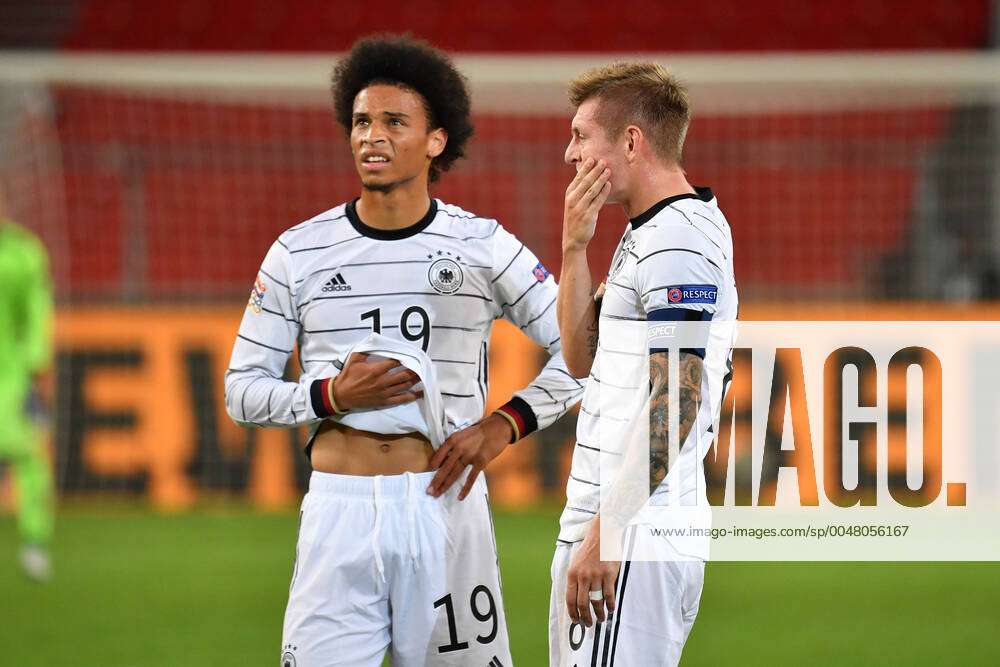  Leroy Sané and Toni Kroos, both wearing the German national team's jersey, are pictured on the pitch during a soccer match.