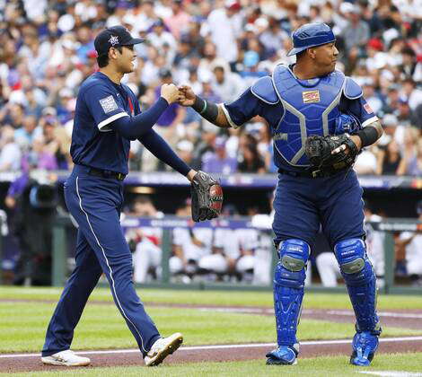 Denver, Colorado. July 13, 2021, The American League's starting pitcher Shohei  Ohtani (L), of the Los Angeles Angels, bumps fists with catcher Salvador  Perez, of the Kansas City Royals, after retiring all