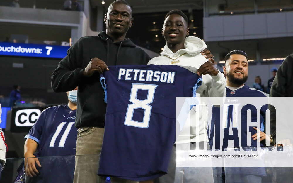 INGLEWOOD, CA - NOVEMBER 7: Tennessee Titans running back Adrian Peterson  #8 father Nelson Peterson holds up his son game worn jersey after the  Tennessee Titans game versus the Los Angeles Rams