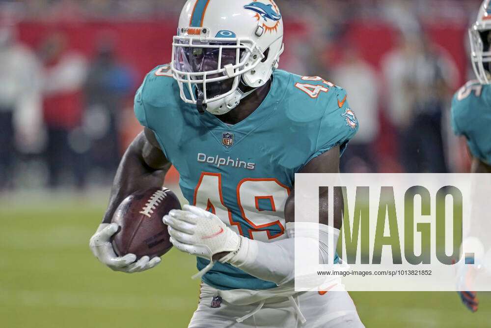 Miami Dolphins Sam Eguavoen (49) heads to the end zone after recovering a  stripped ball from
