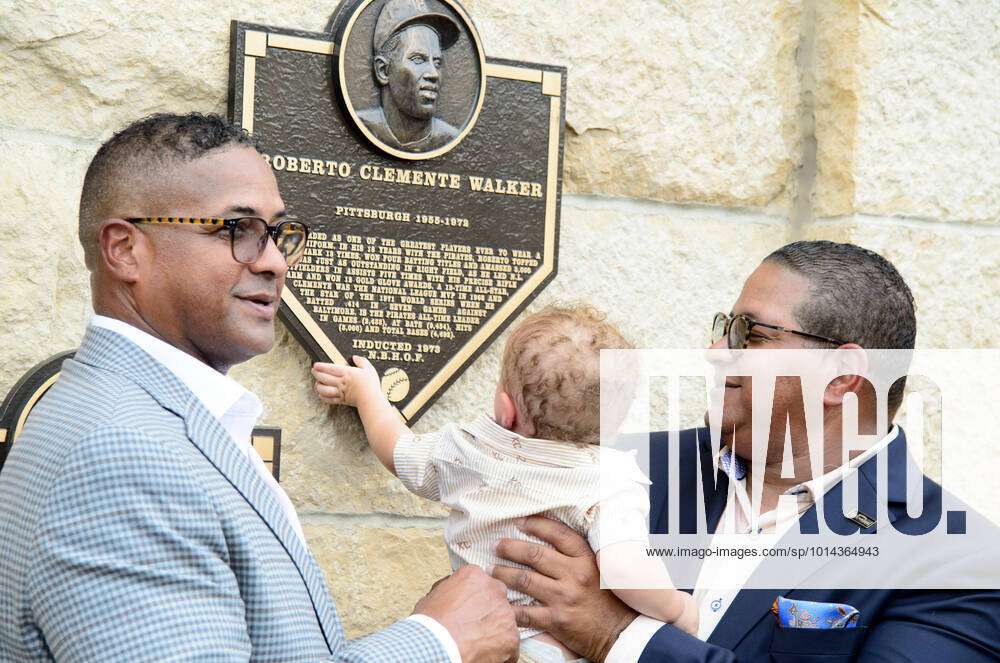 The youngest member of the Clemente family reaches for the plaque as Roberto  Clemente Jr. (l)