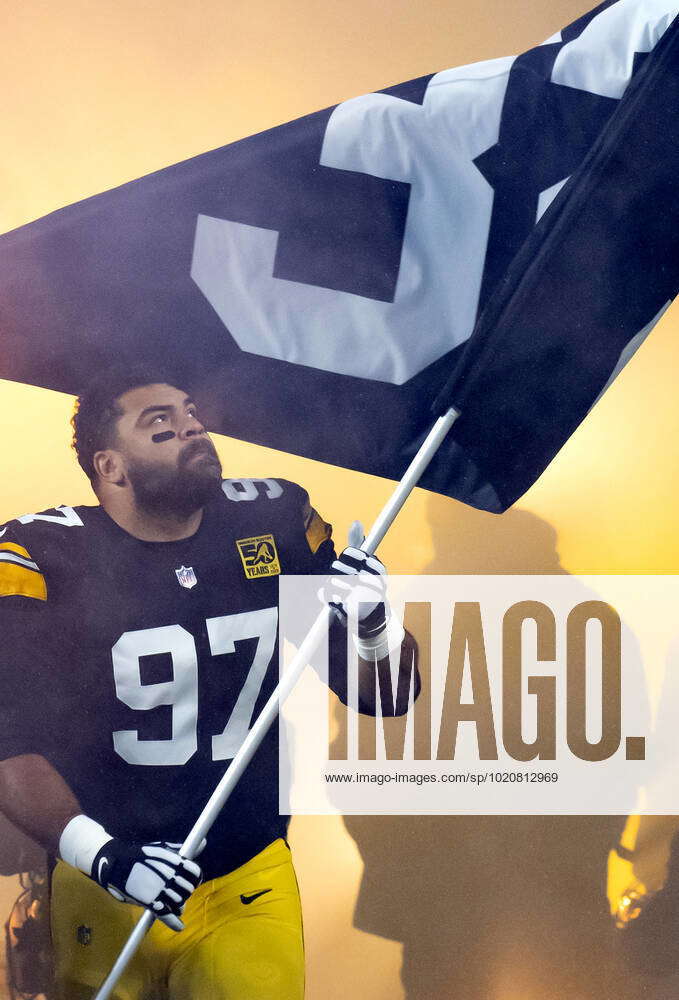 Pittsburgh Steelers defensive tackle Cameron Heyward (97) carries a flag  with Franco Harris number 3