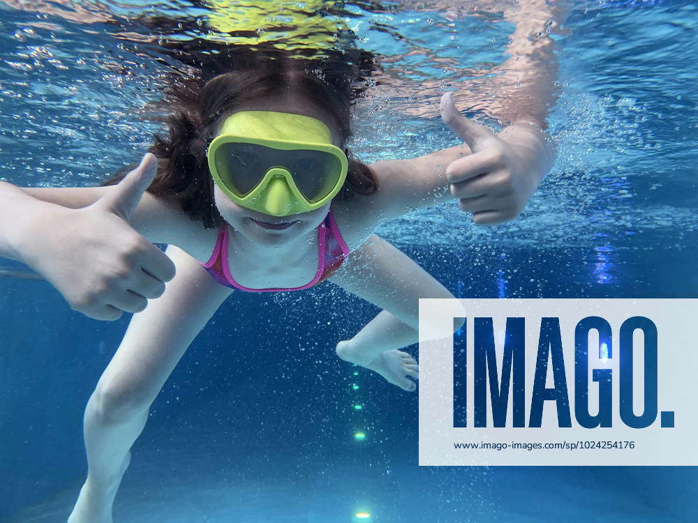 Smiling child in goggles swim, dive in the pool with fun - jump