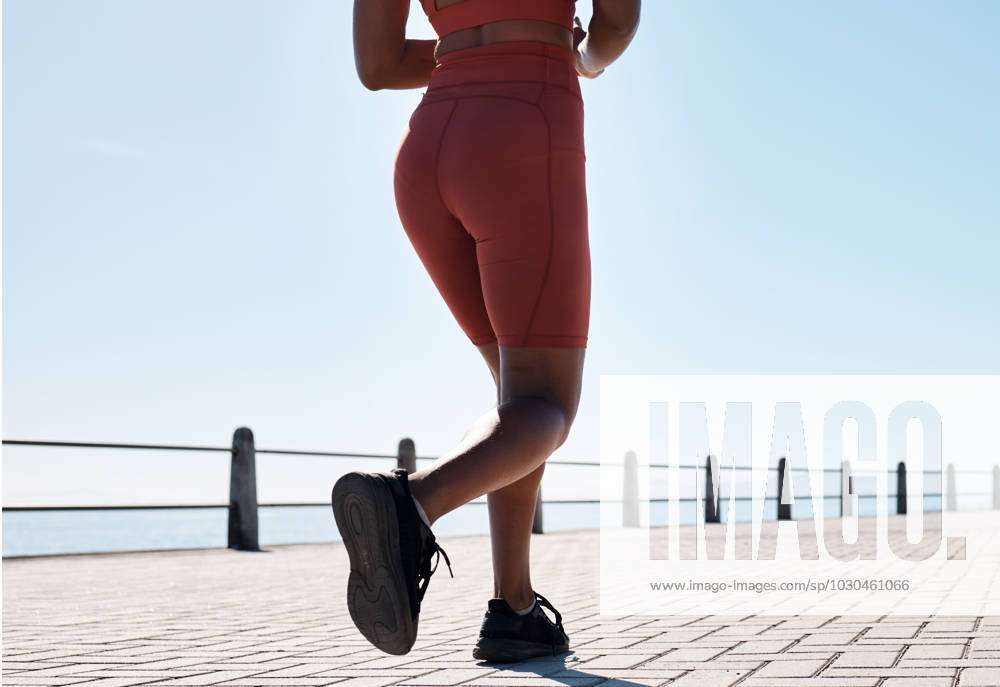 Black woman, legs and running for fitness at beach sidewalk