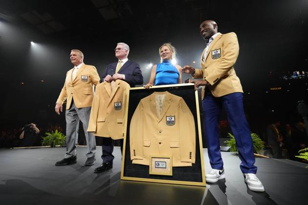 Joe Klecko, left, a member of the Pro Football Hall of Fame Class of 2023,  receives his gold jacket from Howie Long during the gold jacket dinner in  Canton, Ohio, Friday, Aug.