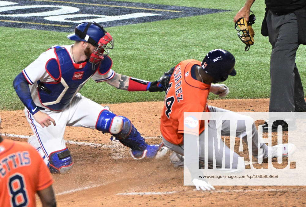Kyle Tucker of the Houston Astros slides by Jonah Heim of the