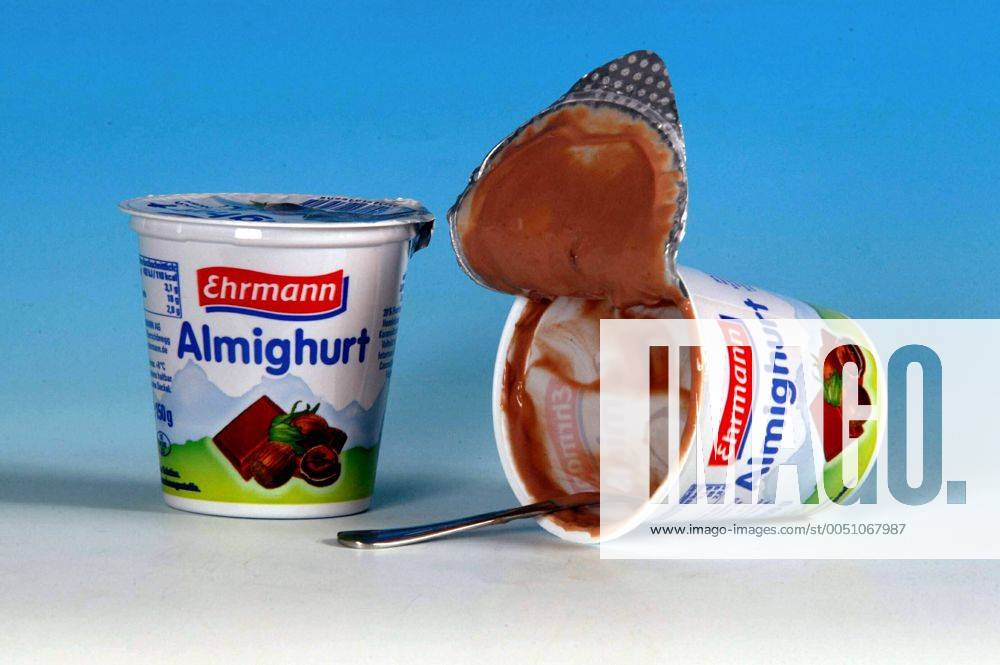 Leerer Schokojoghurt mit Löffel neben einem ungeöffneten Joghurtbecher von