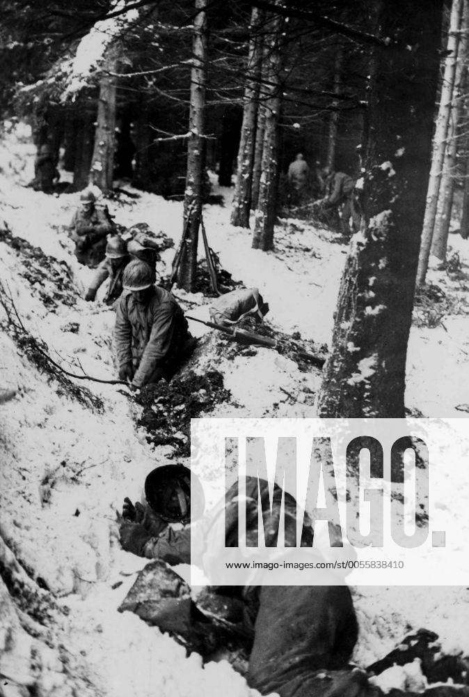 WW2: American soldiers dig hasty foxholes in snow-covered terrain as ...