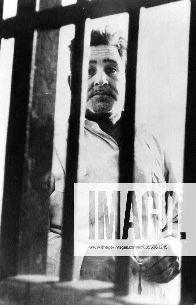 A Batista soldier waits for the firing squad . Through the iron bars of