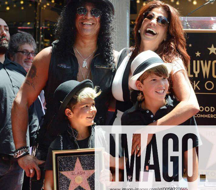 Musician Slash poses with his wife Perla Ferrar and their sons Cash (L ...