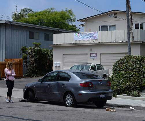 A woman walks past a car in Isla Vista, California on May 26, 2014 that ...