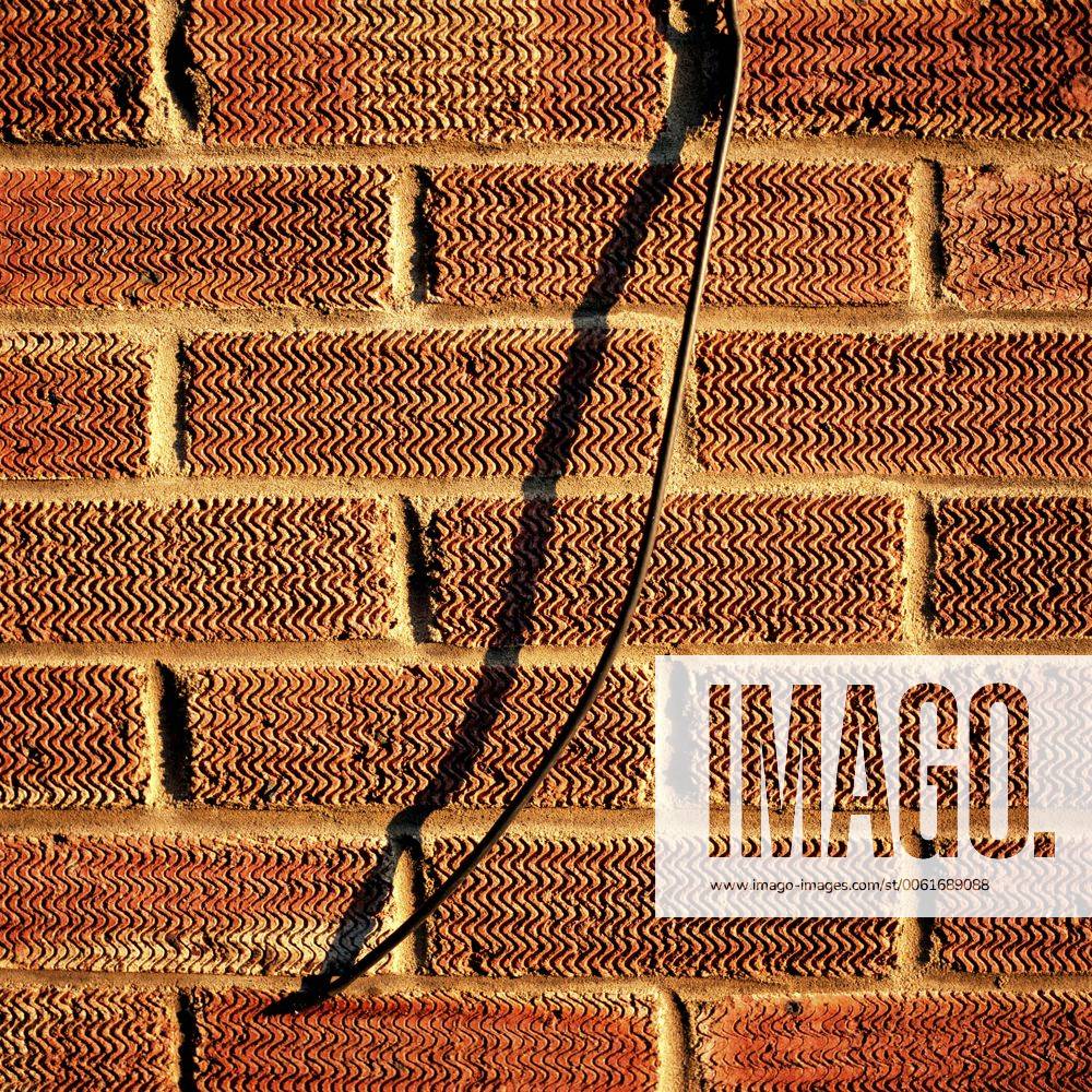 Cable hanging from brick wall Cable hanging from brick wall