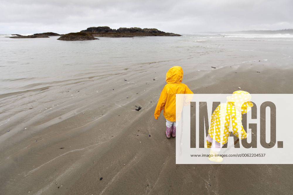 Two children dressed in colorful rain slickers, explore Wickaninnish