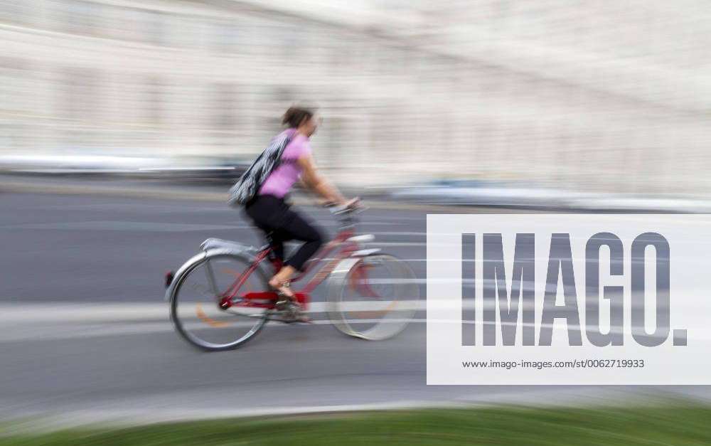 Austria, Vienna, woman riding bicycle on a street Y