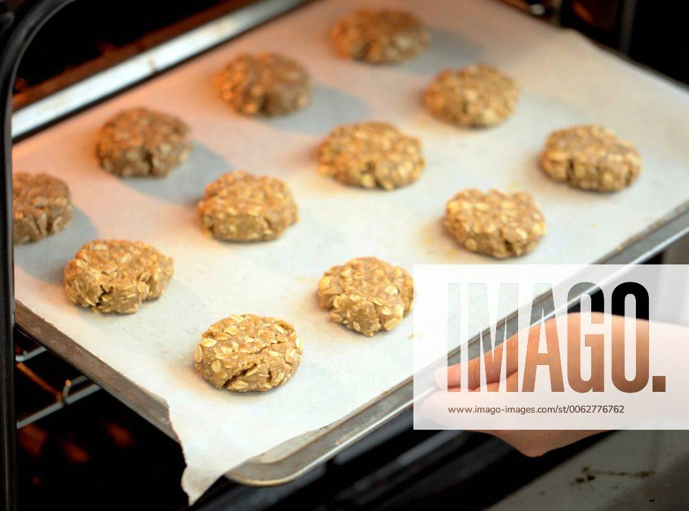 A places ANZAC biscuit into the oven for baking, Sydney, Wednesday