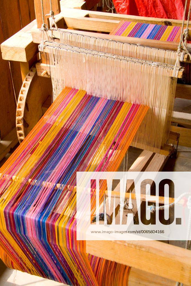 Loom weaving closeup of artwork fabrics by hand in colorful dress in ...