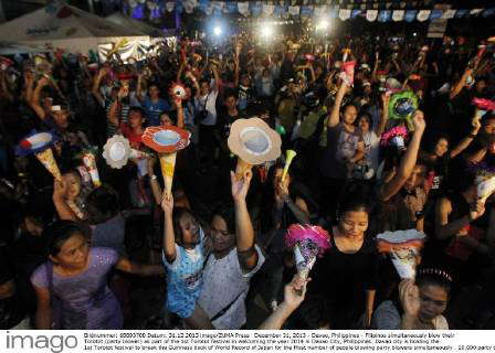 December 31, 2013 - Davao, Philippines - Filipinos simultaneously blow ...