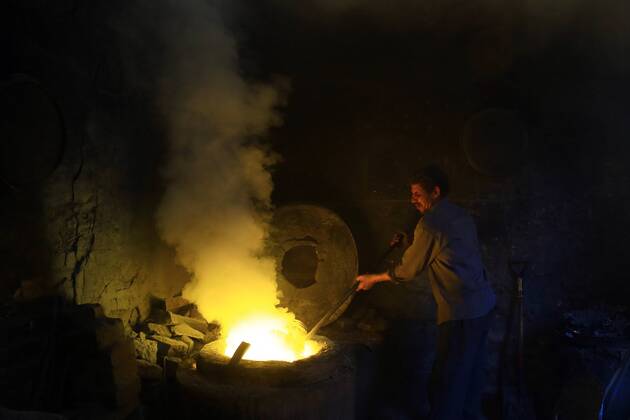 ALEXANDRIA, -- A worker melts scrap metal inside the furnace at a scrap ...