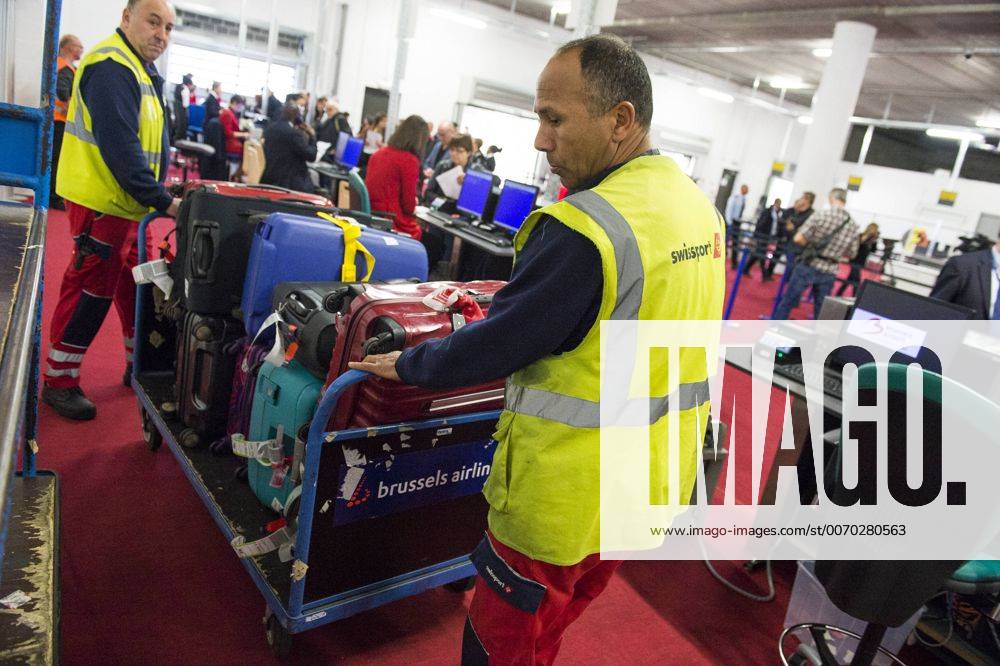 An airport worker handels luggage at the new temporary checkin site at