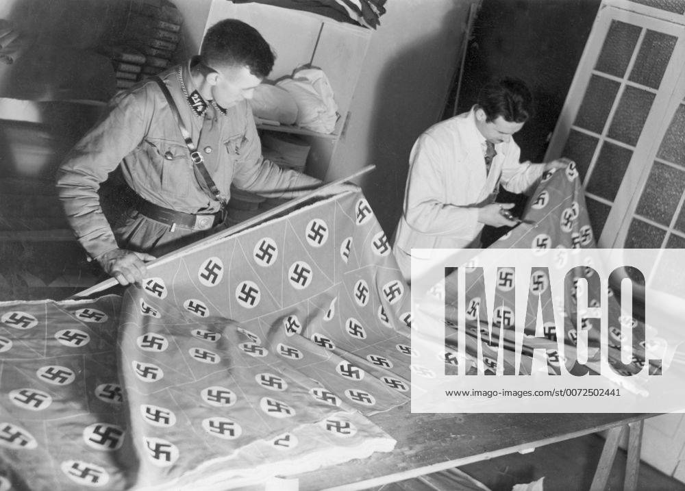 Production of Nazi flags with swastika in Germany, 1933. Swastika is ...