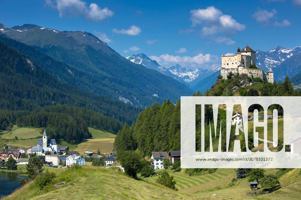 Tarasp Castle and Fontana village surrounded by larch forest in the ...