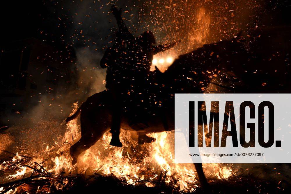 Spain Las Luminarias Festival A man rides a horse through a bonfire as