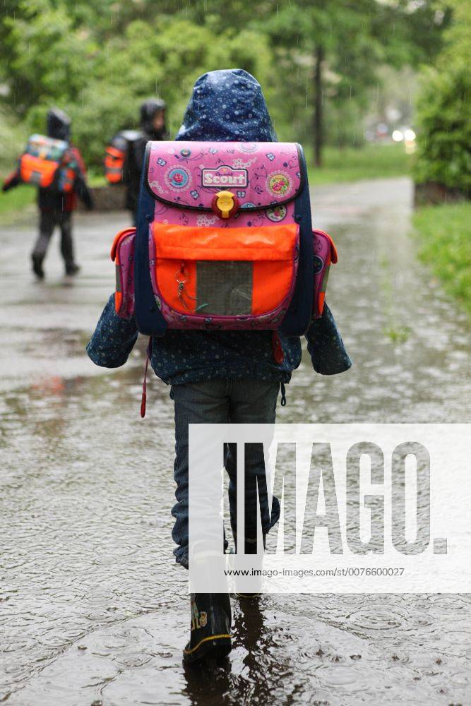 19.05.2010, Berlin, Deutschland Kind laeuft auf dem Weg zur Schule durch eine Pfuetze. (HF