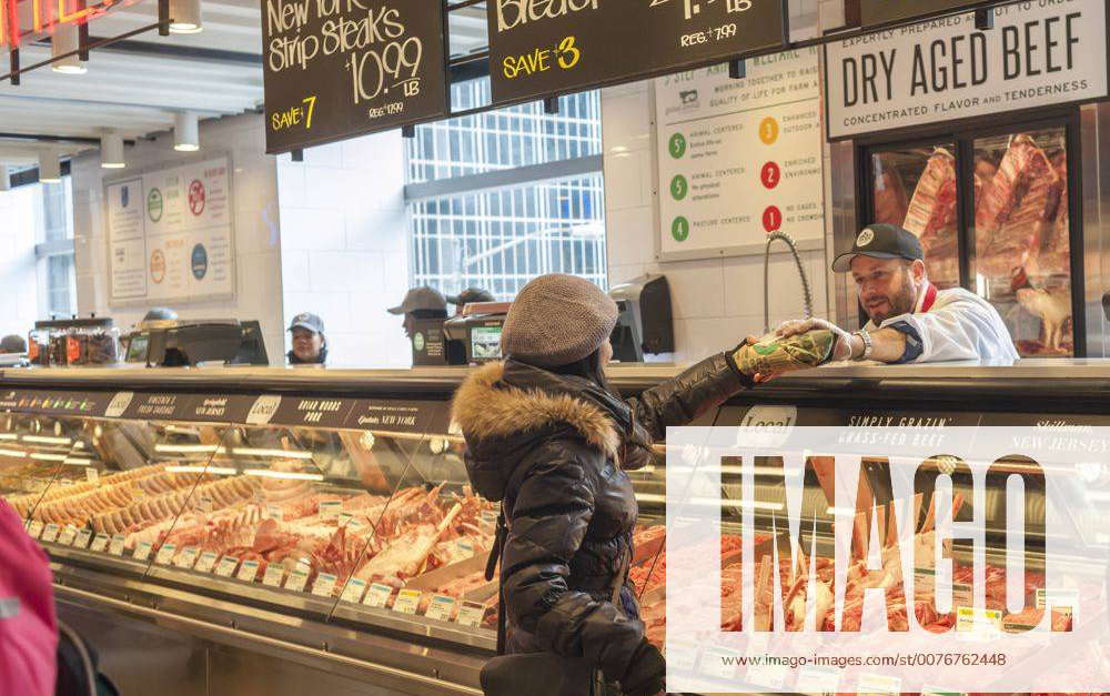 A shopper chooses cuts of meat in the new Whole Foods Market opposite  Bryant Park in New York on opening day Saturday, January 28, 2017. The  store in Midtown Manhattan is the