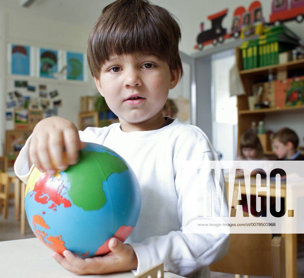 Ein Junge mit einer Weltkugel in einer Montessori Kita in Berlin